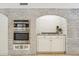 Elegant kitchen features exposed brick archway with stainless steel oven and range at 14401 N Coral Gables Dr, Phoenix, AZ 85023