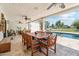 Covered patio with travertine floors featuring a table and chairs with a pool view at 14401 N Coral Gables Dr, Phoenix, AZ 85023
