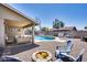 Inviting backyard with a sparkling pool, covered patio, and cozy fire pit area at 18642 N 13Th Ave, Phoenix, AZ 85027