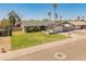 Charming single-story home with well-manicured lawn, complemented by desert landscaping and mature palm trees at 18642 N 13Th Ave, Phoenix, AZ 85027