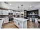 Spacious open concept kitchen with an island, white cabinets, stainless appliances, adjacent laundry and office areas at 18642 N 13Th Ave, Phoenix, AZ 85027