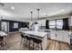 Open-concept kitchen featuring an island with seating, stainless steel appliances, and a seamless connection to a comfortable living area at 18642 N 13Th Ave, Phoenix, AZ 85027