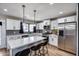 Bright kitchen with stainless steel appliances, white cabinets, stone countertops and pendant lighting at 18642 N 13Th Ave, Phoenix, AZ 85027