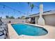 Stunning pool surrounded by palm trees, a patio with seating, and a charming outdoor fireplace at 18642 N 13Th Ave, Phoenix, AZ 85027