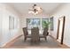 Staged dining room with a table, six chairs, rug, mirror and natural light at 221 N Ironwood St, Gilbert, AZ 85234