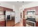 Kitchen with stainless steel refrigerator and appliances, and dark wood cabinets at 221 N Ironwood St, Gilbert, AZ 85234