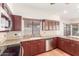 Kitchen with stainless steel dishwasher, granite countertops, and dark wood cabinets at 221 N Ironwood St, Gilbert, AZ 85234