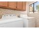 Laundry room featuring side-by-side washer and dryer with upper cabinets at 221 N Ironwood St, Gilbert, AZ 85234
