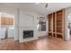 Cozy living room with a fireplace, built-in bookshelves, and an adjacent laundry room at 221 N Ironwood St, Gilbert, AZ 85234