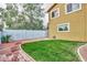 Well-maintained backyard with lush green grass, brick-paved walkway, and a neutral painted wall at 3121 W Greenway Rd, Phoenix, AZ 85053