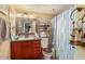 Bright bathroom featuring a vanity, tiled shower, and decorative shelving over the toilet at 3121 W Greenway Rd, Phoenix, AZ 85053
