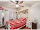 Well-lit bedroom with hardwood floors, ceiling fan, and a comfortable bed with decorative pillows at 3121 W Greenway Rd, Phoenix, AZ 85053