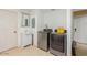 Practical laundry room with modern washer and dryer, sink, and storage cabinets at 3121 W Greenway Rd, Phoenix, AZ 85053