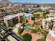 Stunning aerial view of condo complex with community pool, mature trees, and beautiful desert landscaping at 4200 N Miller Rd # 503, Scottsdale, AZ 85251