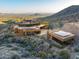 Aerial view of the luxurious desert home showcasing its unique architecture and expansive surrounding landscape at 43105 N 102Nd St, Scottsdale, AZ 85262