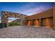 Spacious driveway leading to a modern home with a stone accent wall and attached three-car garage at 43105 N 102Nd St, Scottsdale, AZ 85262