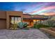The exterior of a modern home with large windows, desert landscaping, and a paver driveway at 43105 N 102Nd St, Scottsdale, AZ 85262