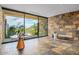 Bright foyer features stone accent wall, tile floors, and a large glass sliding door with a view of desert landscaping at 43105 N 102Nd St, Scottsdale, AZ 85262