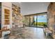 Spacious foyer boasts stone accent wall, tile floors, and a large glass sliding door with backyard views at 43105 N 102Nd St, Scottsdale, AZ 85262