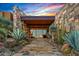 Inviting home featuring a grand stone entrance with desert landscaping and a view through a glass front door at 43105 N 102Nd St, Scottsdale, AZ 85262