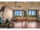 Spacious gym with hardwood floors, large windows boasting beautiful mountain views, and exercise equipment at 43105 N 102Nd St, Scottsdale, AZ 85262