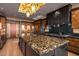 Modern kitchen boasts a large island with stone countertop, designer lighting, and high-end stainless steel appliances at 43105 N 102Nd St, Scottsdale, AZ 85262