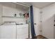 Functional laundry room with washer, dryer, storage shelf, and convenient access to the house at 5352 E Diamond Ave, Mesa, AZ 85206