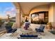 A covered balcony with stone columns, tile floors, comfortable seating, and beautiful views at 6621 N Arizona Biltmore Cir, Phoenix, AZ 85016