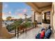 A spacious covered balcony boasts seating, tile floors, stone pillars, and scenic views at 6621 N Arizona Biltmore Cir, Phoenix, AZ 85016