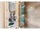Bright bathroom featuring a glass shower, stone tiling, and views to the pool and outdoor patio at 6621 N Arizona Biltmore Cir, Phoenix, AZ 85016