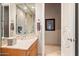 Well-lit bathroom with a marble vanity, towel rack, and large mirror next to an open door at 6621 N Arizona Biltmore Cir, Phoenix, AZ 85016