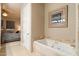 Elegant bathroom with a large soaking tub, tiled floors, and luxurious design for a spa-like experience at 6621 N Arizona Biltmore Cir, Phoenix, AZ 85016
