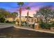 Elegant home with palm trees, manicured lawn, and a circular driveway at sunset at 6621 N Arizona Biltmore Cir, Phoenix, AZ 85016