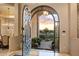 Open foyer with ornate iron door and view of lush landscaping and sunset at 6621 N Arizona Biltmore Cir, Phoenix, AZ 85016