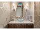 Chic powder room with vessel sink, custom mirror, elegant lighting, and designer wallpaper at 6621 N Arizona Biltmore Cir, Phoenix, AZ 85016