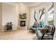 Cozy sitting room features a fireplace, plaid armchairs, and scenic views from the arched window at 6621 N Arizona Biltmore Cir, Phoenix, AZ 85016