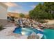 Pool and spa with a rock waterfall feature and desert landscaping at 6621 N Arizona Biltmore Cir, Phoenix, AZ 85016
