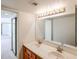 Bright bathroom with double sinks, long vanity, and large mirror at 10 E Betty Elyse Ln, Phoenix, AZ 85022