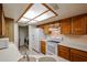 Efficient kitchen featuring white appliances and ample cabinet space and laundry room at 10 E Betty Elyse Ln, Phoenix, AZ 85022