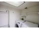 Bright laundry room with washer, dryer, storage shelves and tiled ceiling at 10 E Betty Elyse Ln, Phoenix, AZ 85022