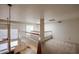 Bright loft features neutral carpet, natural light, and white railing overlooking the living room at 10 E Betty Elyse Ln, Phoenix, AZ 85022