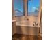 Bright bathroom features a soaking tub with natural light from windows and modern fixtures at 1024 W Ayrshire Trl, San Tan Valley, AZ 85143