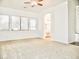 Brightly lit carpeted bedroom with ceiling fan and view into attached bathroom at 1024 W Ayrshire Trl, San Tan Valley, AZ 85143