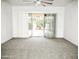 A bright living room with plush carpet and sliding glass doors leading to the backyard at 1024 W Ayrshire Trl, San Tan Valley, AZ 85143