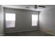A carpeted bedroom with two windows and a ceiling fan for natural light at 11218 W Glenrosa Ave, Phoenix, AZ 85037