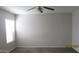 A carpeted bedroom with a ceiling fan and a window letting in light at 11218 W Glenrosa Ave, Phoenix, AZ 85037