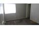 A gray toned bedroom featuring carpet and natural light from a window at 11218 W Glenrosa Ave, Phoenix, AZ 85037