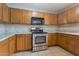 Kitchen features stainless steel appliances, ample oak cabinets, and granite countertops at 11218 W Glenrosa Ave, Phoenix, AZ 85037