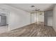This bedroom has wood-look floors, ceiling fan, mirrored closet doors, and an adjoining kitchen at 115 S Stardust Ln, Apache Junction, AZ 85120