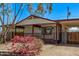 Front exterior featuring a covered porch, carport, and low-maintenance landscaping at 115 S Stardust Ln, Apache Junction, AZ 85120